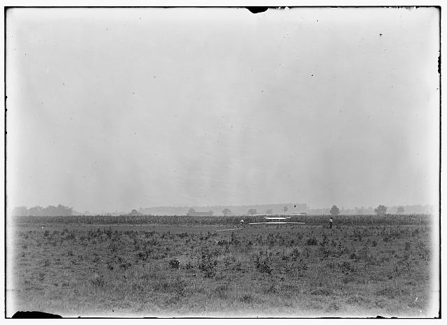 [Long-range view of machine on launching track, probably Wilbur and Orville standing on either side; Huffman Prairie, Dayton, Ohio]