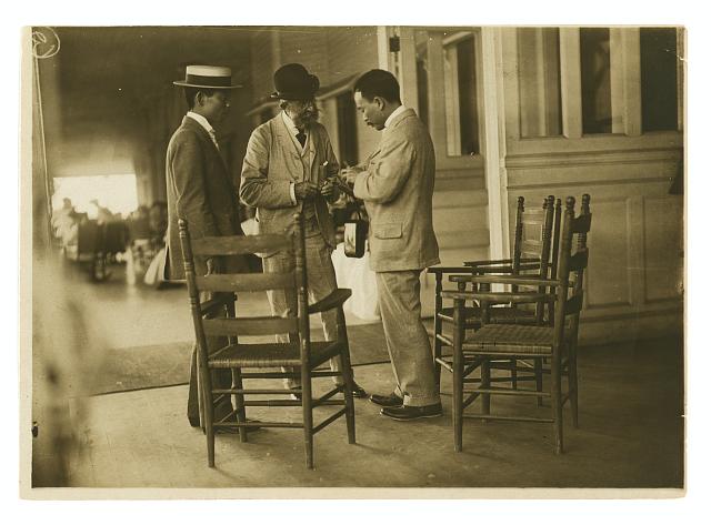 [Two Japanese men and one American(?) man, probably journalists, conversing on the veranda of the Wentworth Hotel, Portsmouth, N.H.]