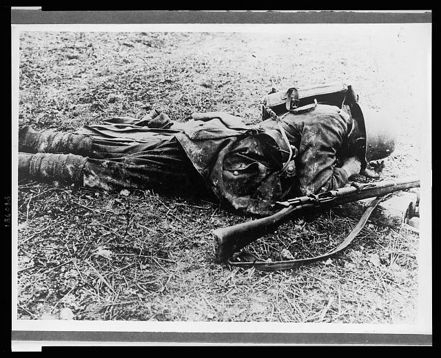 [A German soldier, probably a sniper, laying on the ground ]