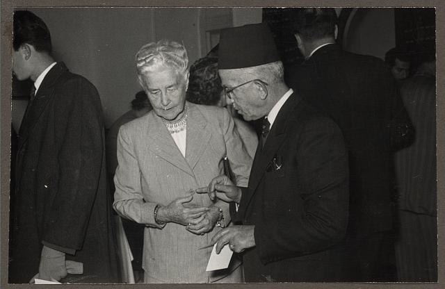 [Mrs. Bertha Vester listening to Mr. Hanna Atalla, three-quarter length portrait, at American Colony bazaar, probably in Jerusalem]