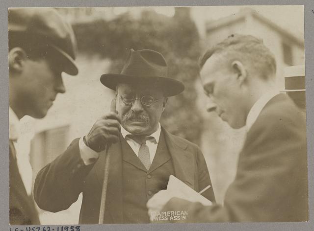 [Theodore Roosevelt speaking with two men, probably reporters]