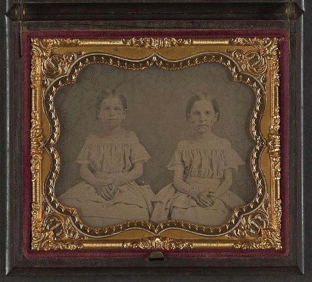 [Two unidentified young girls, probably sisters, wearing matching dresses]
