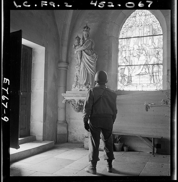 [Soldier looking at a statue of the Madonna and Child in a church, probably in Europe during World War II]
