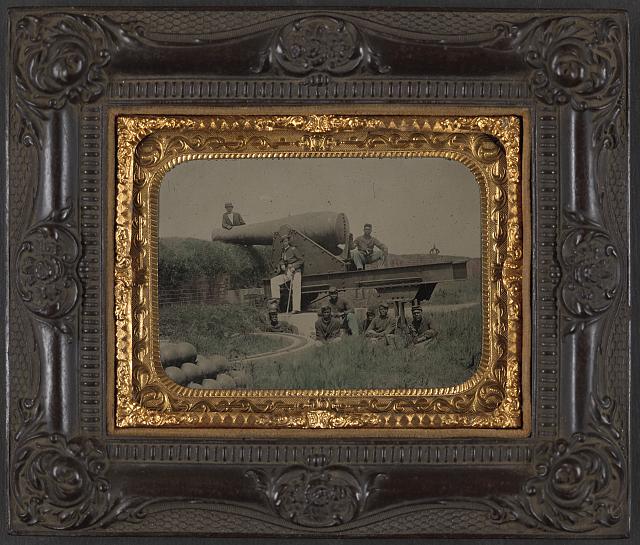 [Lieutenant Samuel K. Thompson of Co. C, 54th U.S. Colored Troops Infantry Regiment with unidentified soldiers posed with a 10" Rodman cannon at an earthwork fort, probably Fort Massachusetts, Mississippi]