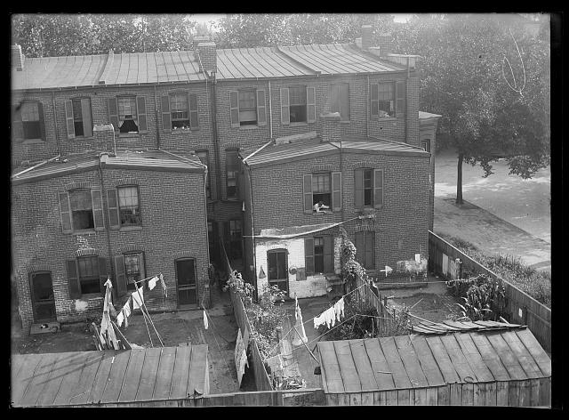 [An elevated view of row houses probably in S.W., showing laundry hanging on clothesline in backyards]