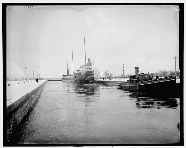 [Cargo ship and tug in canal, probably Sault Sainte Marie Canal]