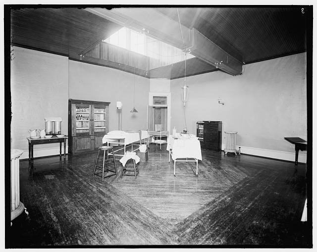 [Room with medicine cabinet, basins, and massage or treatment table, probably the Ypsilanti mineral bath house, Ypsilanti, Michigan]