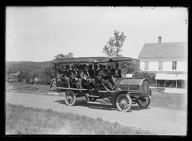 [Tour bus on road, probably in Adirondack mountains]