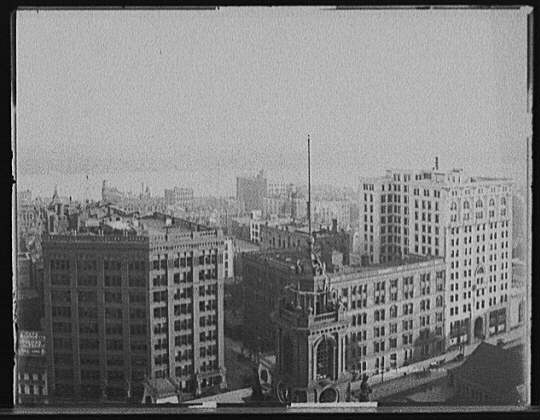[Church tower, commercial buildings and waterfront, probably Detroit]