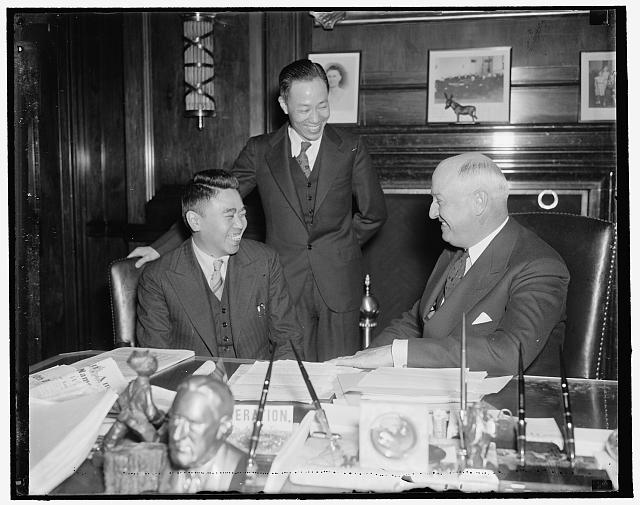 PMG Farley receives official of China Post Office Confederation. Washington, D.C., April 14. PMG Farley probably was telling on of his stock campaign jokes to Chi Hsueh Fan, official of the National Post Office Confederation of China, as this picture was made. Farley received the official today with Pei Yuan Ho, (standing) first Secretary of the Chinese Embassy, 4/14/1937