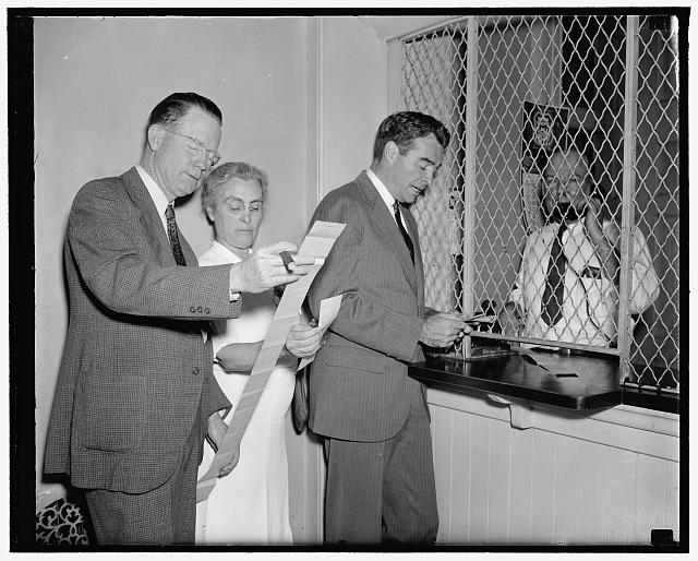 Sue sign off early adjournment of Congress. Washington, D.C., June 10. While Congress will probably not adjourn until sometime next week, its members are already besieging the railroad ticket office at the Capitol for transportation home. Pictured here getting their mileage are, left to right: Rep. William M. Colmer, Mississippi; Rep. Virginia Jenckes; Rep. Matthew J. merritt, New Jersey; and P.H. McClune, ticket agent, 6/10/38