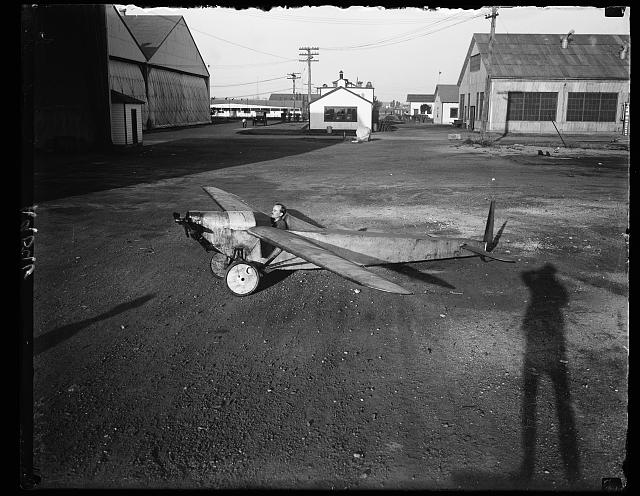 Probably the smallest plane in the world. Built by Edw. F. Allen of Wash, D.C., who was formerly test pilot for Army Air Service during the world war. Plane is equipped with 9 horsepower motorcycle engine and weighs only 205 lbs. with wing spread of 27 ft. Mr. Allen, in cockpit, flies it often and recently attained height of 1800 ft. capable of making 63 mph