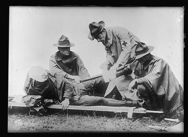 First Aid At the Fighting Front. An improvised splint is made for a wounded soldier with the aid of a gun strap. All wounds of whatever nature are immediately cared for which is probably the main reason for the extreme low death rate among our enlisted men