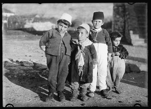 Montenegro's best dressed children. In Montenegro clothing is probably more scarce than in any other country in Europe and the children are the greatest sufferers from lack of it. This group was among the best dressed to be found in Podgoritza so the others may be pictured accordingly. Every day miserably clad urchins pour into the Junior Red Cross of America orphanage and distribution stations and receive clothing that has the stamp of some American school boy or girl on it. Some of it has been worn before but most of it is new in many cases made by the donors. Always it fills a need desperate beyond the imagination of the well-dressed and comfortably shed American child