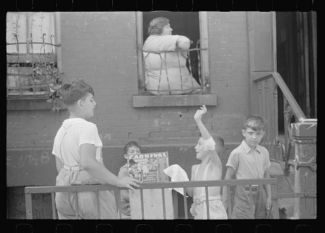 New York, New York. 61st Street between 1st and 3rd Avenues. Children playing in the street