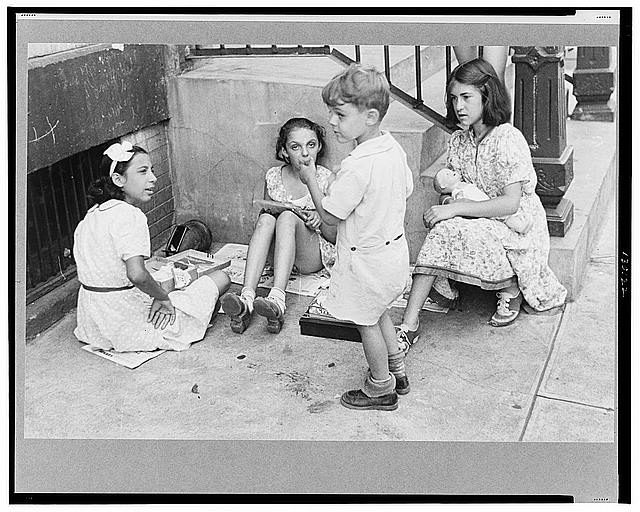 New York, New York. 61st Street between 1st and 3rd Avenues. Children playing in the street
