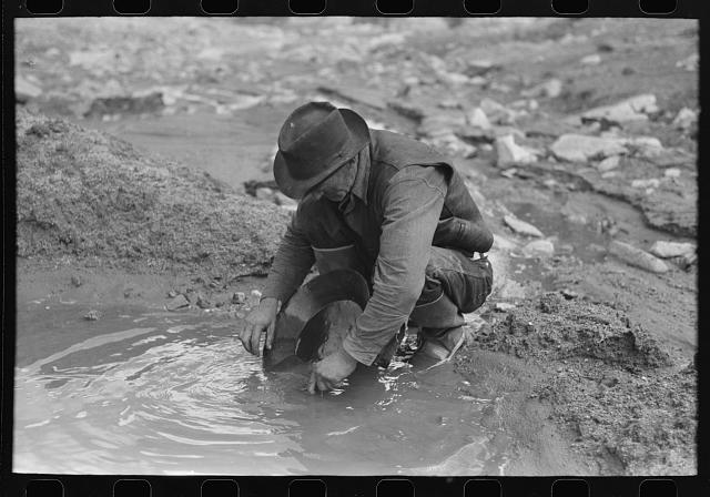 [Untitled photo, possibly related to: Prospector panning gold. The light objects are probably not gold as it is very unusual to find pieces this large in this section. They are probably mica (fools gold) or mercury which is used to attract the gold. Pinos Altos, New Mexico]