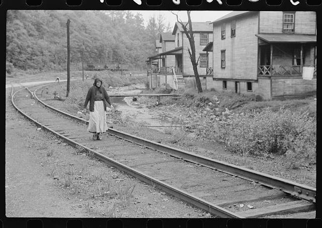 Woman (probably Hungarian) coming home along railroad tracks in coal mining town, company houses at right, Pursglove, Scotts Run, West Virginia