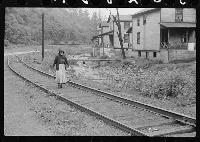[Untitled photo, possibly related to: Woman (probably Hungarian) coming home along railroad tracks in coal mining town, company houses at right, Pursglove, Scotts Run, West Virginia]