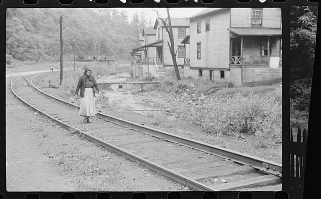 [Untitled photo, possibly related to: Woman (probably Hungarian) coming home along railroad tracks in coal mining town, company houses at right, Pursglove, Scotts Run, West Virginia]
