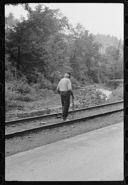 [Untitled photo, possibly related to: Woman (probably Hungarian) coming home along railroad tracks in coal mining town, company houses at right, Pursglove, Scotts Run, West Virginia]