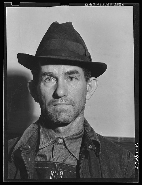 Unemployed miner, Herrin, Illinois. General caption: Williamson County, Illinois, once produced 11,000,000 tons of coal per year, and led the state in output. Since 1923, output has steadily declined until now it falls short of 2,000,000 tons. At one time, sixteen mine-whistles blowing to work could be heard from the center of Herrin. Now only two mines are running and those will probably be abandoned within the next year. The Herrin office of the UMWA (United Mine Workers of America) was once the most active in the state. Today it is no longer self-sustaining. These pictures were taken in the Herrin UMWA office on a day when the mines were not working. They show the type of miners still employed in Williamson County but faced with the almost certain prospect of being discarded by the industry when the last mine is closed
