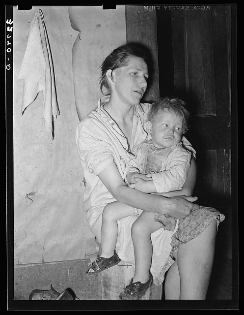 Mother and child. This woman, wife of an ex-farmer now living on relief, had pellagra in an advanced stage. She has had some treatment and shown great improvement but there were still evidences of mental disturbances. She was the mother of twelve children. The child in her arms has malaria as have probably the entire family. Jefferson, Texas