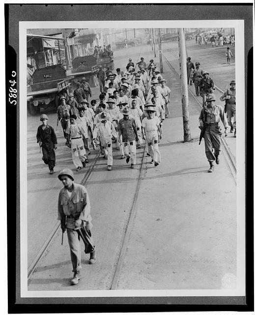 Japanese prisoners of war being guarded by Americans--probably in the Philippines