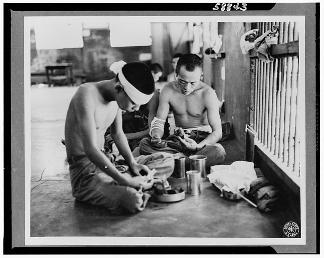 Japanese prisoners of war being guarded by Americans--probably in the Philippines