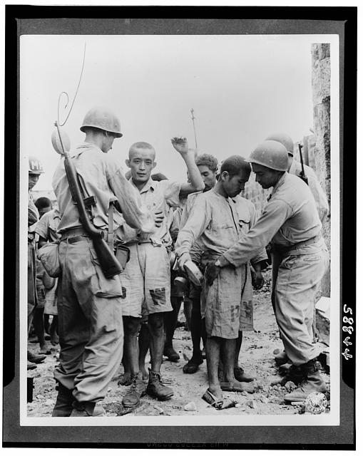 Japanese prisoners of war being guarded by Americans--probably in the Philippines
