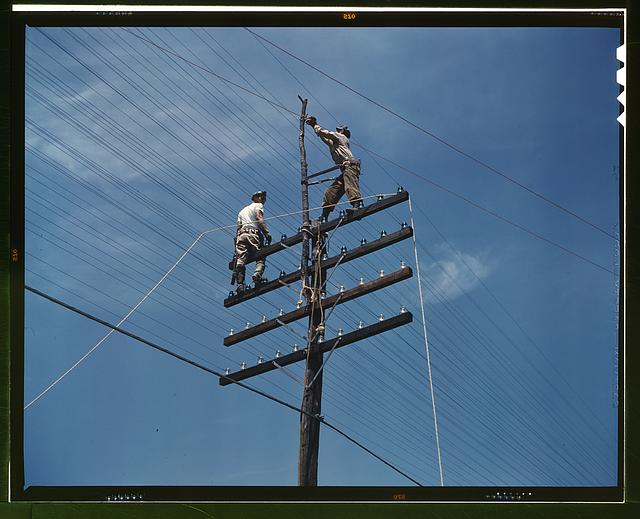 [Men working on telephone lines, probably near a TVA dam hydroelectric plant]