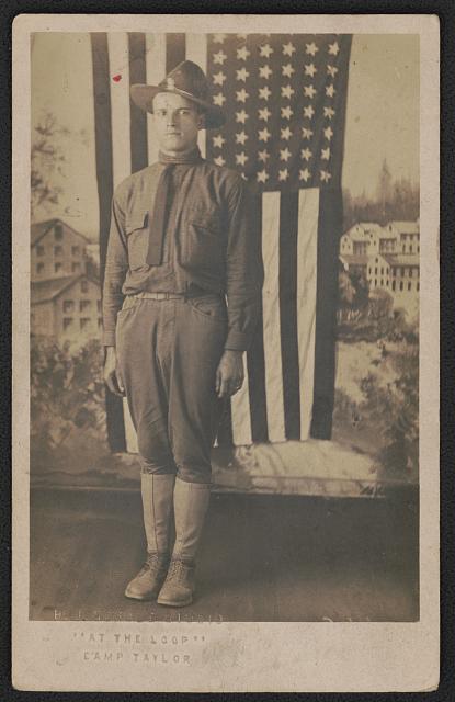 [Frank Rice in uniform in front of American flag and painted backdrop showing military camp, probably Camp Taylor, Louisville, Kentucky]