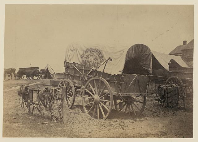 [Covered wagon for "Headquarters baggage" and saddlery, probably a Civil War military camp]