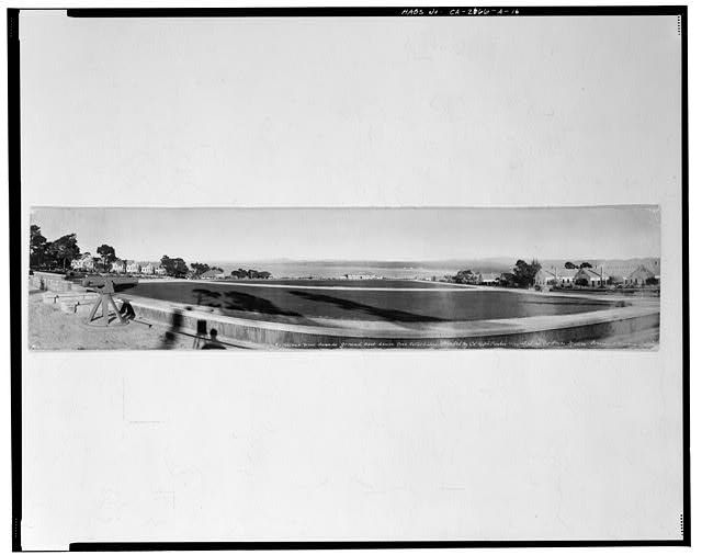 16.  'EXCELLENT NEW PARADE GROUND BEST SINCE POST ESTABLISHED. STARTED BY COL. RALPH PARKER, FINISHED BY COL. TROUPE MILLER, PRESIDIO OF MONTEREY CALIFORNIA.' No date, probably ca. 1936. No signature, photographer probably Anton C. Heidrick. This panoramic view looks east over Soldier Field to the Bay, from the cannons at the west end. Original hand tinted silver gelatin print measures 90.4 cm by 20.2 cm, flush mounted on mat board. - Presidio of Monterey, Soldier Field, Monterey, Monterey County, CA