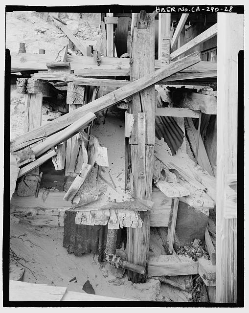28.  DETAIL OF PROBABLY FLUMEWAY, LOOKING SOUTH FROM WALKWAY OVER CYANIDE TANKS. WATER PASSING THROUGH THE PELTON WHEEL FLOWED THROUGH THIS FLUMEWAY TO EXIT THE MILL, ALONG THE WASTE WATER FROM THE CONCENTRATION AND CLASSIFYING PROCESS. - Skidoo Mine, Park Route 38 (Skidoo Road), Death Valley Junction, Inyo County, CA