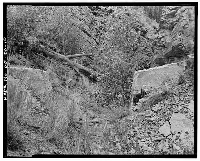 10.  CANAL CUT THROUGH SHALE BEDROCK ON PROMINENT POINT, LOOKING NORTH-NORTHEAST. NOTE CONCRETE ABUTMENTS PROBABLY INSTALLED IN 1935 TO PREVENT WATER FROM ESCAPING THROUGH A CANAL BANK BREACH. - Snake River Ditch, Headgate on north bank of Snake River, Dillon, Summit County, CO