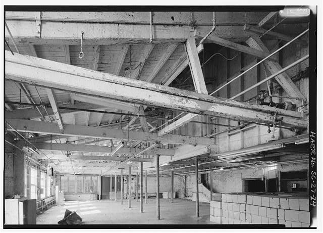 24.  VIEW INSIDE BRICK ADDITION ON SOUTHWEST END OF ORIGINAL MILL, LOOKING NORTH. NOTE WOOD TRUSSES AND FLUTED COLUMNS (CAST IRON WITH EGYPTIAN REVIVAL CAPITAL). THIS SECTION OF THE MILL WAS PROBABLY PART OF THE WEAVE ROOM ADDITIONS DURING THE 1860s. - Graniteville Mill, Marshall Street, Graniteville, Aiken County, SC