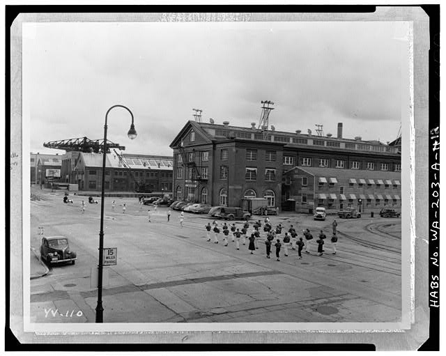 12.  Photocopy of photograph in the collection of Photographic Branch, Puget Sound Naval Shipyard, Bremerton, WA. Original is labelled: Yard Photo 110. Date unknown, probably 1940's. Photographer unknown. HABS negative is a 4x5' copy negative. Perspective view of NW corner of Building 78 with marching band in foreground. Compare to 1917 photo (WA-203-A-1); note removal of chimney and addition of two extra floors at NW corner of building. - Puget Sound Naval Shipyard, Administration Building, Farragut Avenue, Bremerton, Kitsap County, WA